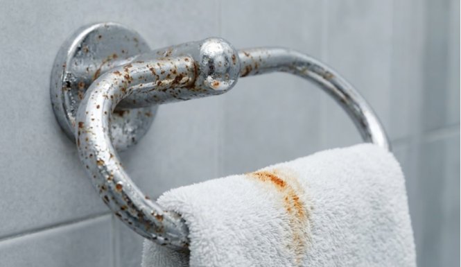 Corroded chrome towel ring with rust stains.