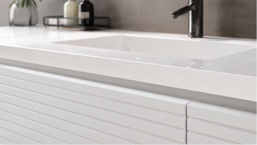 Close-up of white quartz bathroom vanity countertop and ribbed cabinet drawers